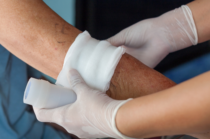 nurse practitioner taking care of a seniors wound